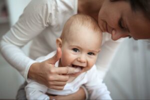 La femme essuie la gomme du bébé